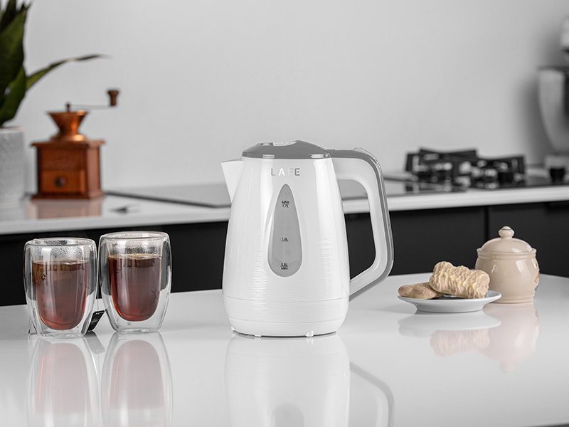 Un bollitore elettrico bianco Lafe su un bancone da cucina con tè e biscotti.