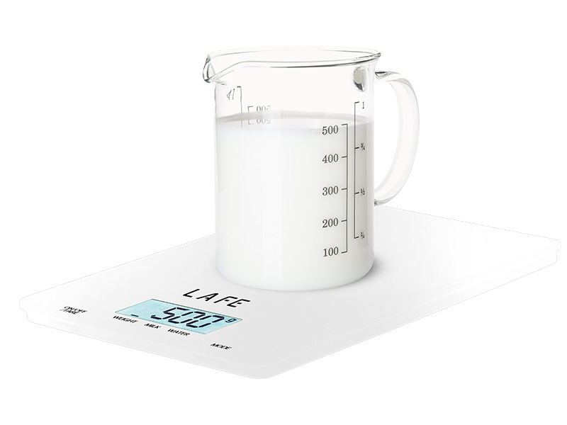 Eine Glasmesskanne mit Milch steht auf einer weißen digitalen Küchenwaage mit der Aufschrift LAFE.