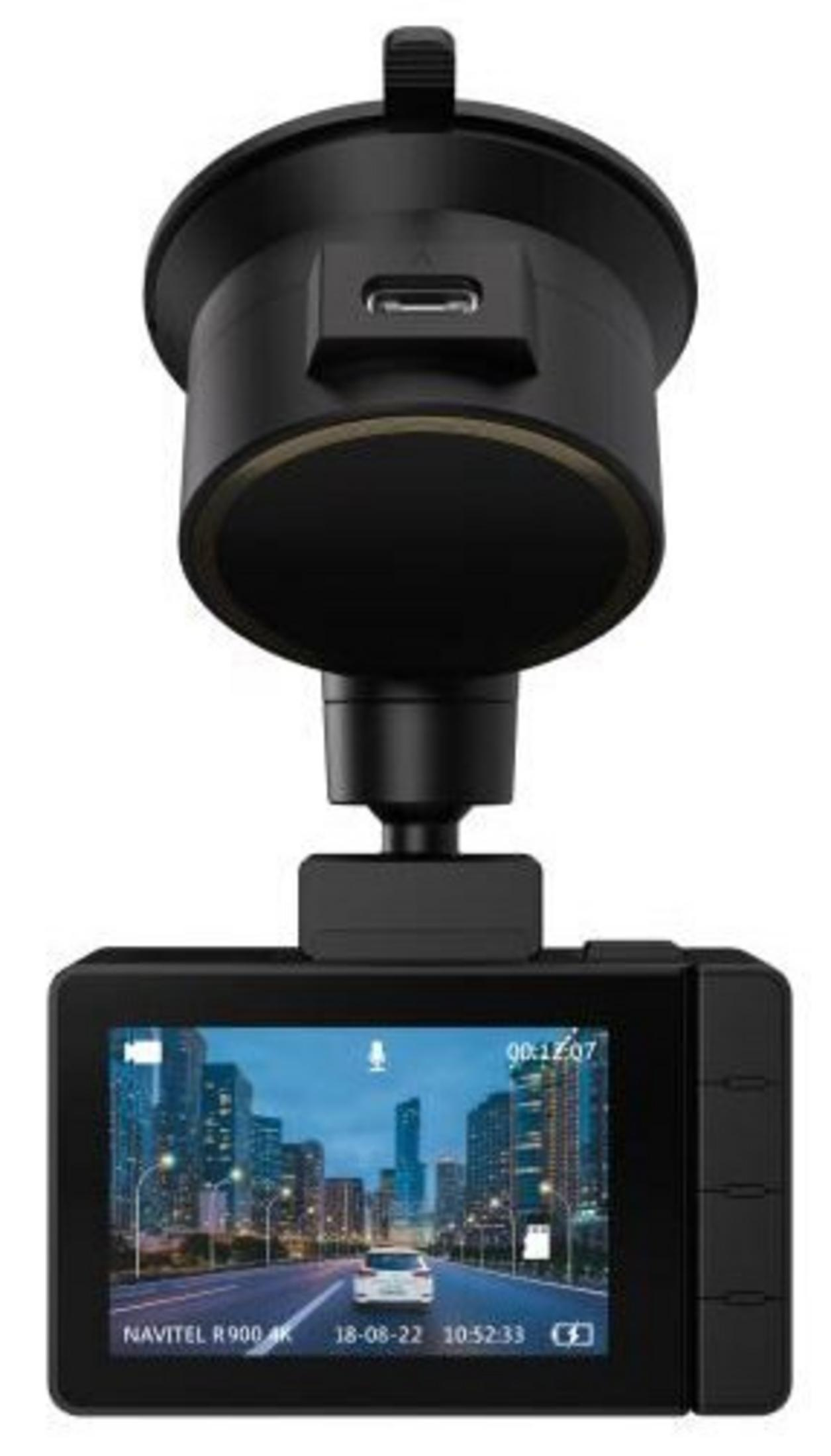 Eine schwarze Dashcam mit Saugnapfhalterung zeigt eine Stadtstraße auf dem Bildschirm vor weißem Hintergrund.