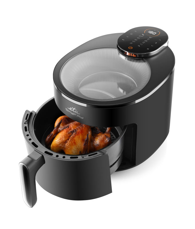 Una friggitrice ad aria digitale nera con coperchio in vetro contiene un pollo intero arrosto.