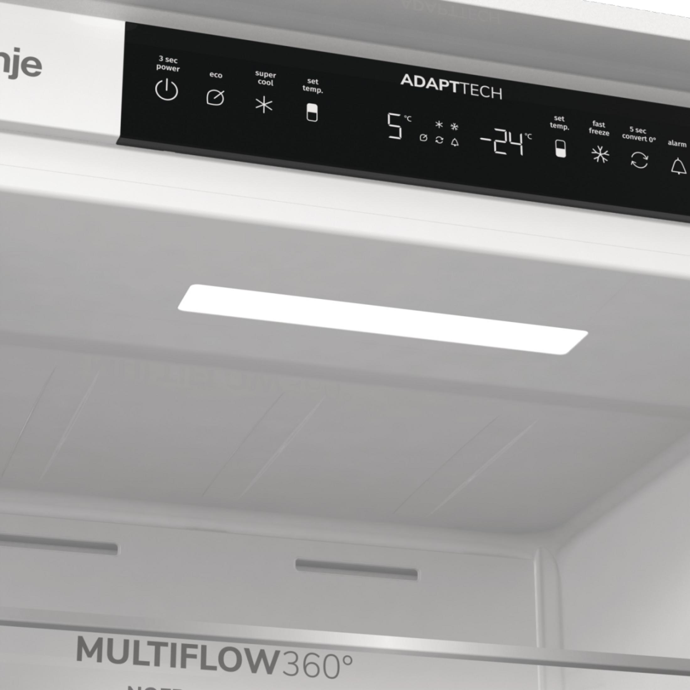 Innenansicht eines weißen Kühlschranks mit AdaptTech-Bedienfeld, LED-Beleuchtung und Multiflow 360-Schriftzug.