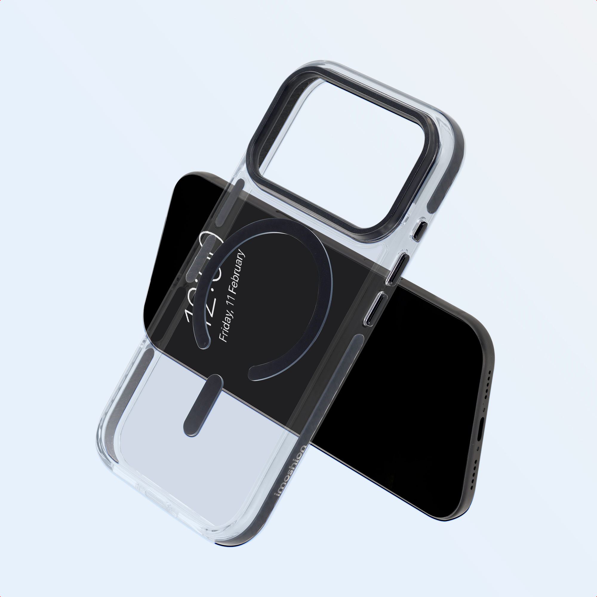 Eine transparente Schutzhülle mit magnetischem Ring liegt schräg über einem schwarzen Smartphone auf hellem Hintergrund.