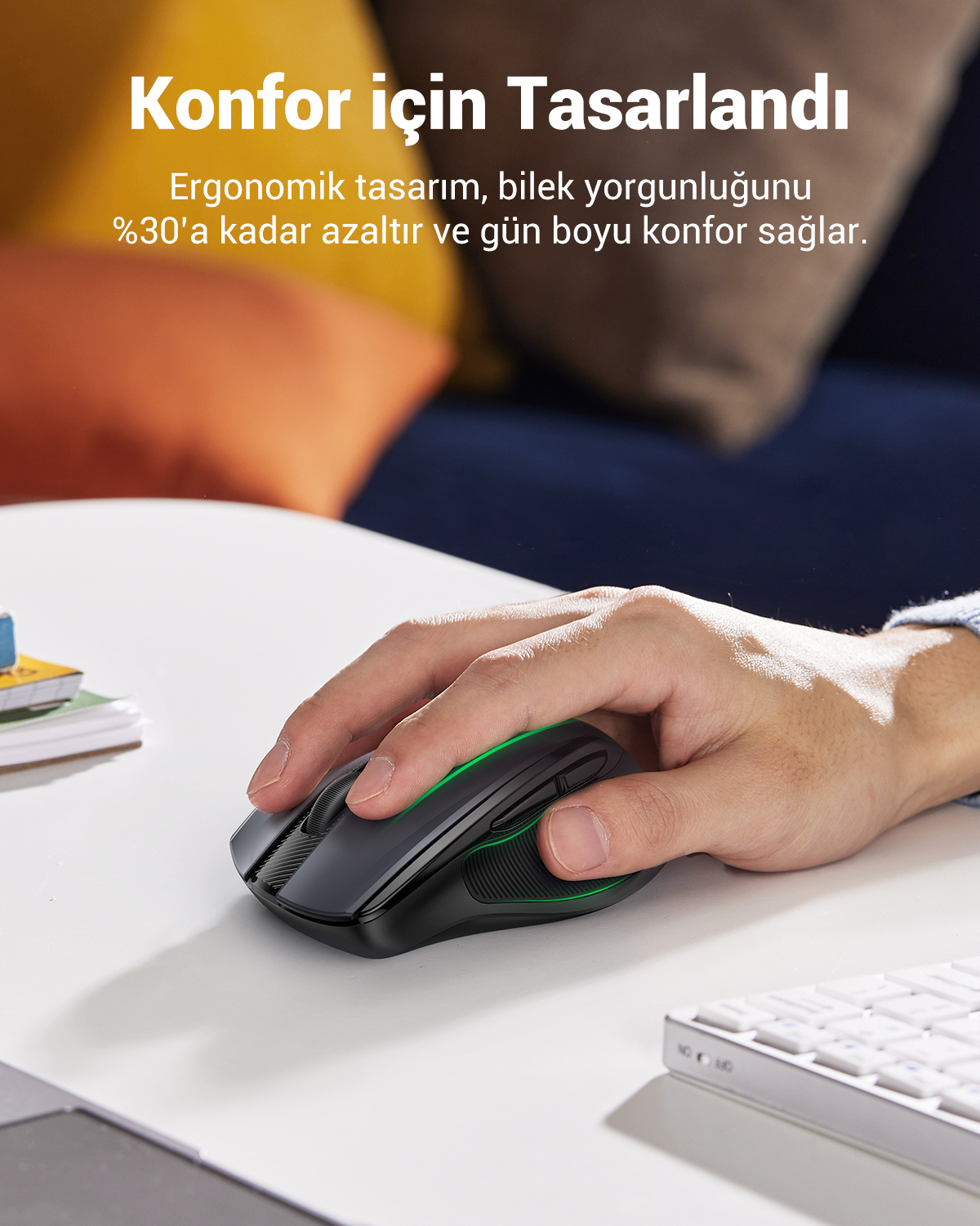 Bir el, beyaz bir masada siyah ergonomik bir fare kullanıyor.