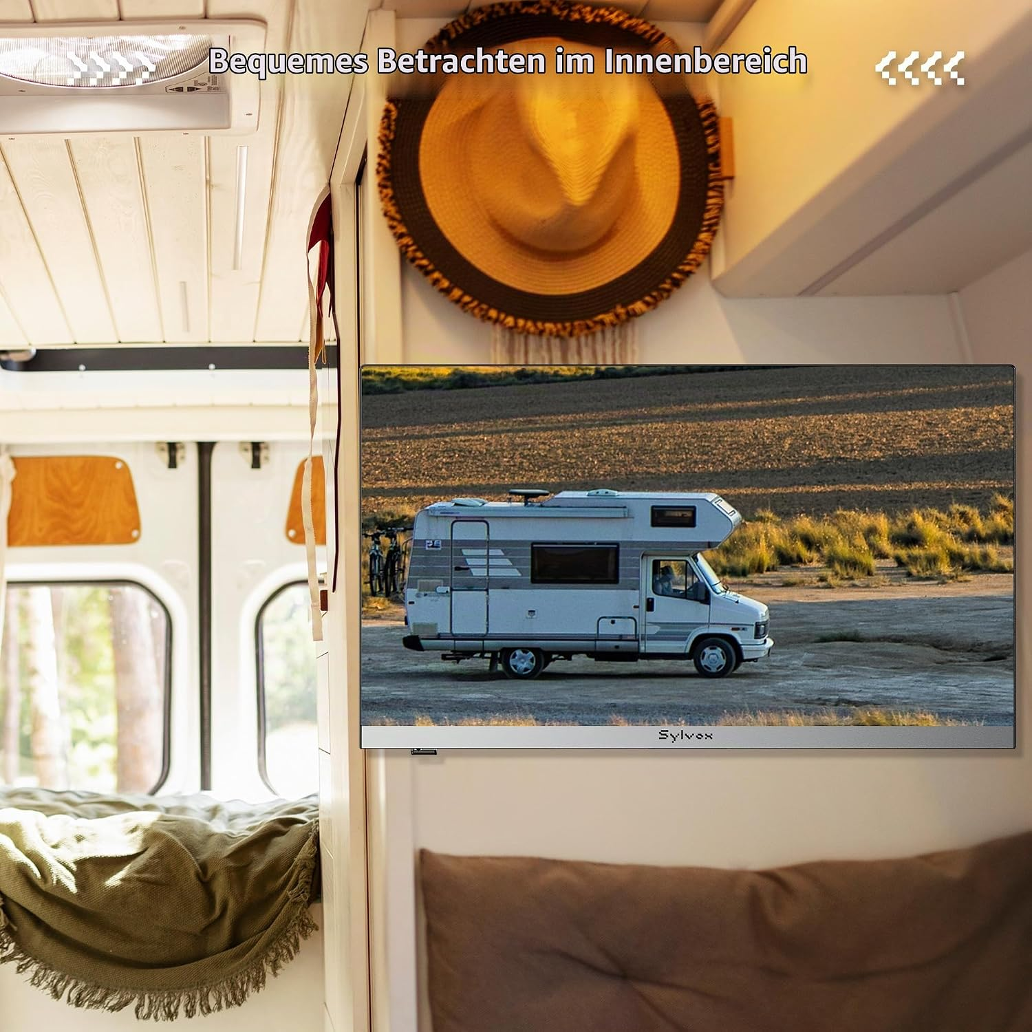 Ein Wohnmobil-Innenraum mit einem Fernseher an der Wand, der ein Wohnmobil in einer Landschaft zeigt.