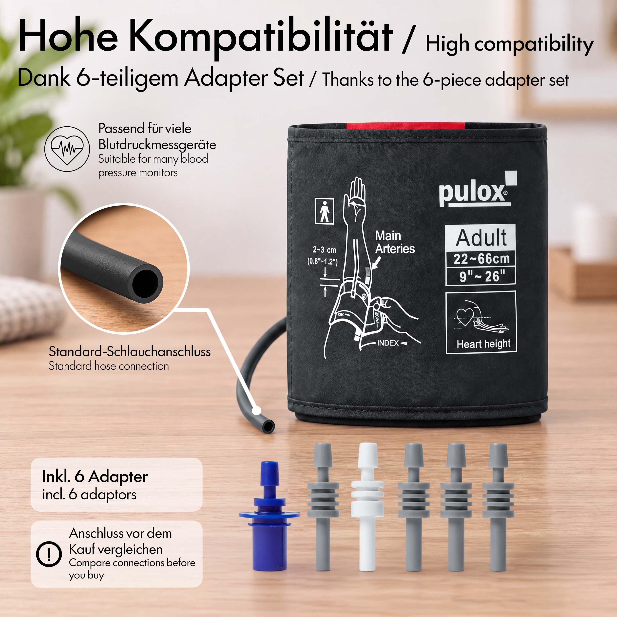 Schwarze Pulox-Blutdruckmanschette mit sechs verschiedenen grauen und blauen Adaptern auf einem Holztisch.