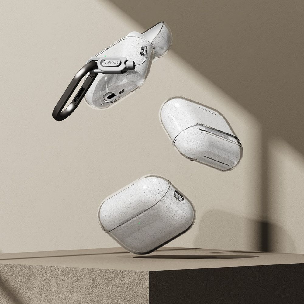 Tre custodie per AirPods bianche fluttuanti con glitter in gusci trasparenti sopra un piedistallo beige.