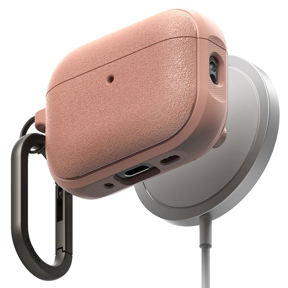 Custodia rosa testurizzata per AirPods con moschettone nero su sfondo bianco con caricatore wireless.