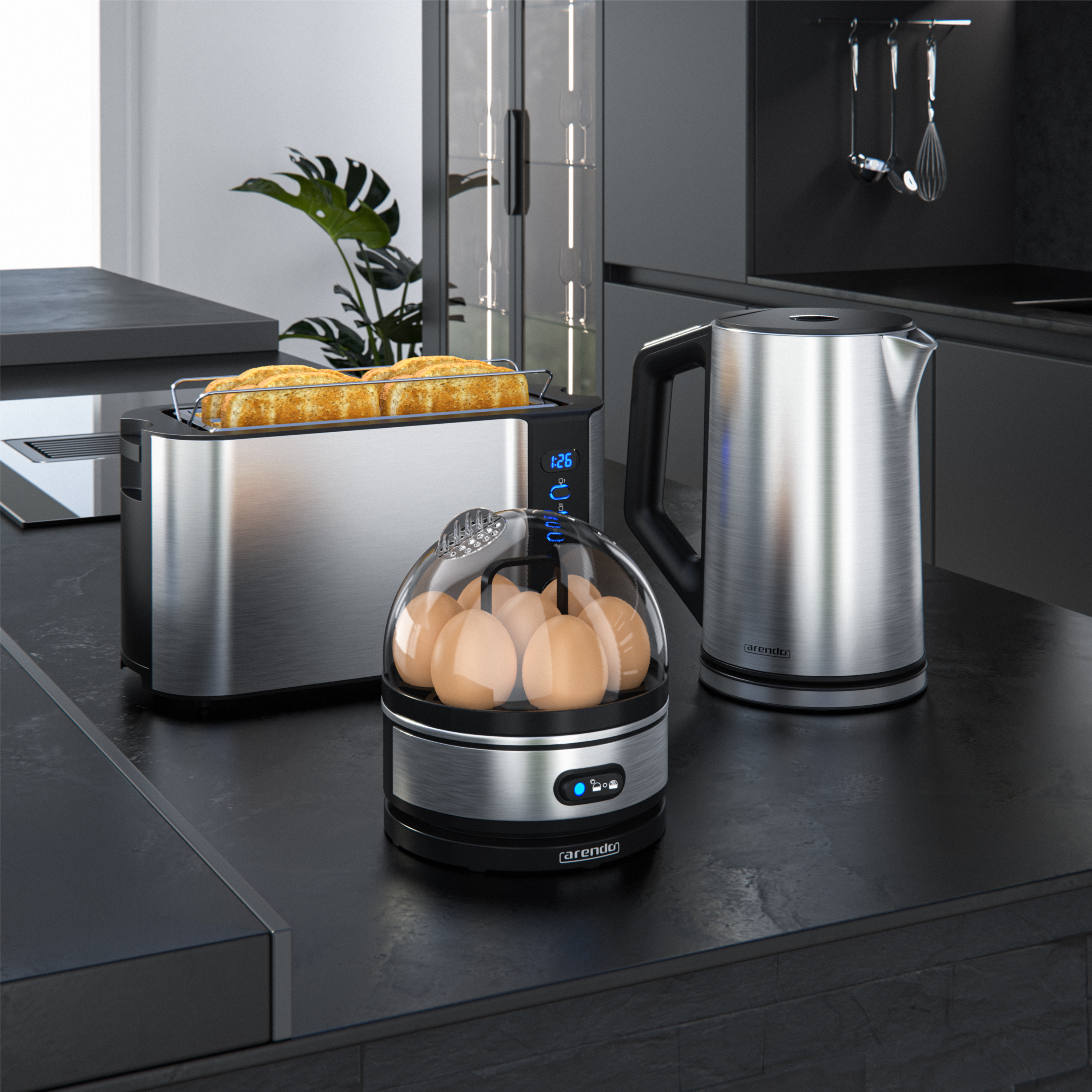 Edelstahl-Küchengeräte auf einer dunklen Arbeitsplatte: Toaster mit Brot, Eierkocher und Wasserkocher in einer modernen Küche.