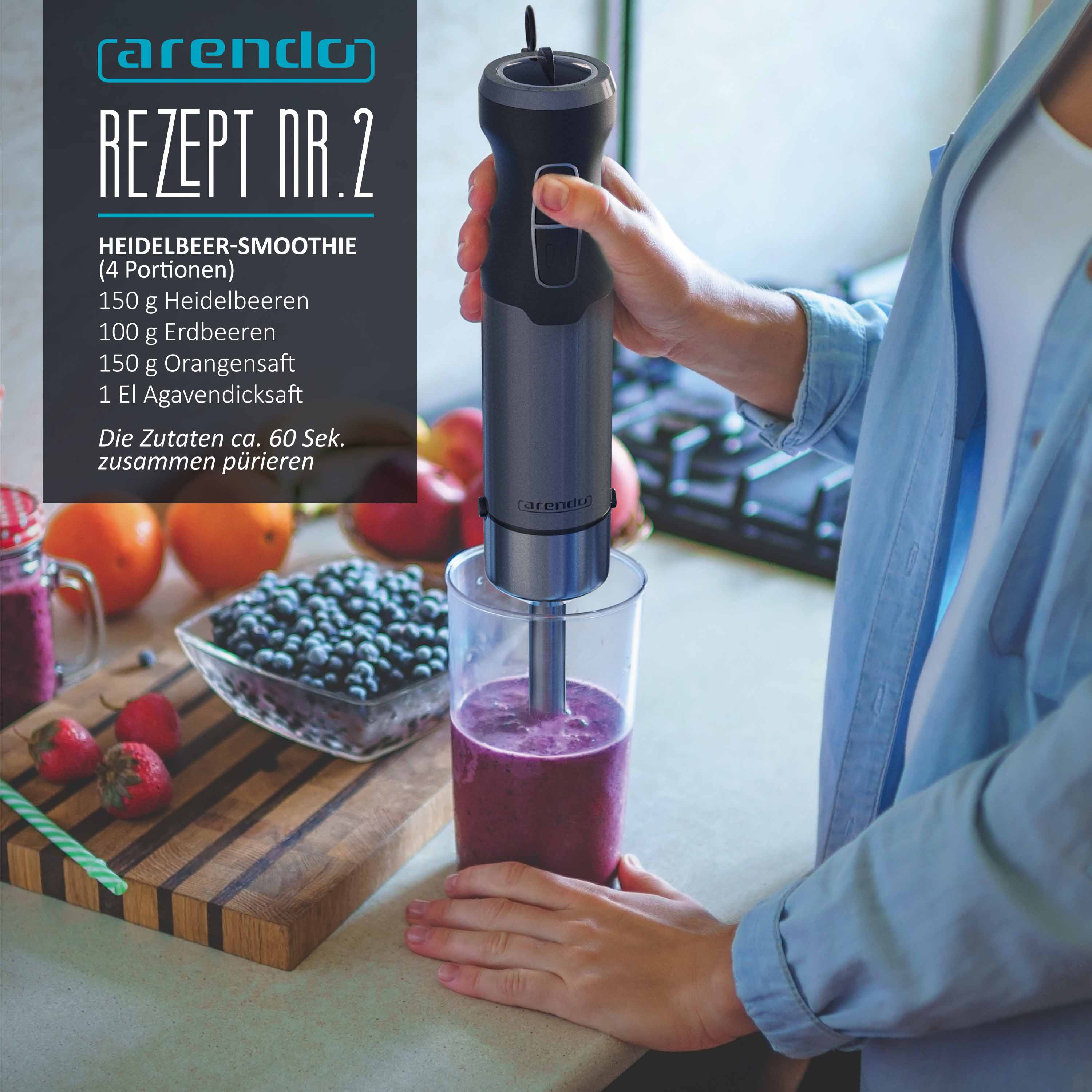 Eine Person benutzt einen grauen Stabmixer, um einen Blaubeersmoothie in einem Glas zu zubereiten.
