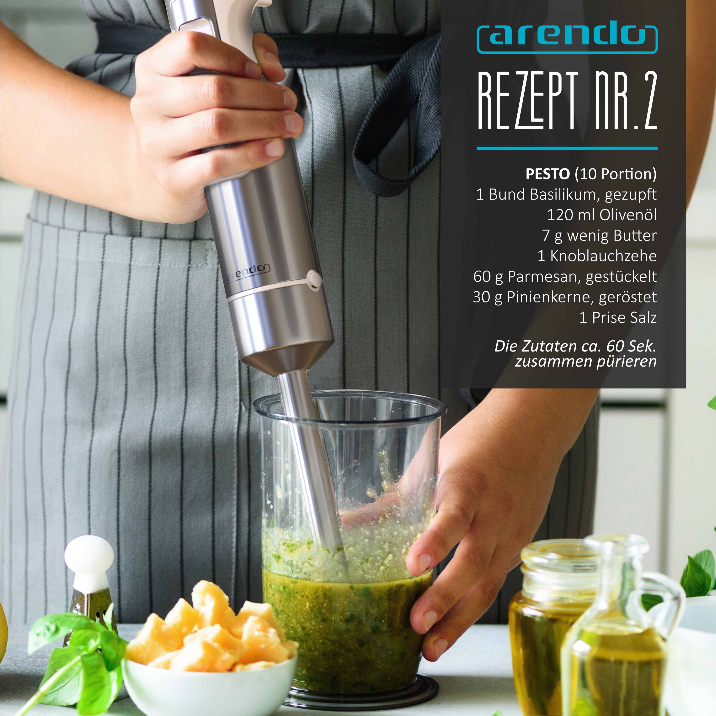 Eine Person benutzt einen Stabmixer in einem Becher mit grüner Pesto, daneben Parmesan und Öl.