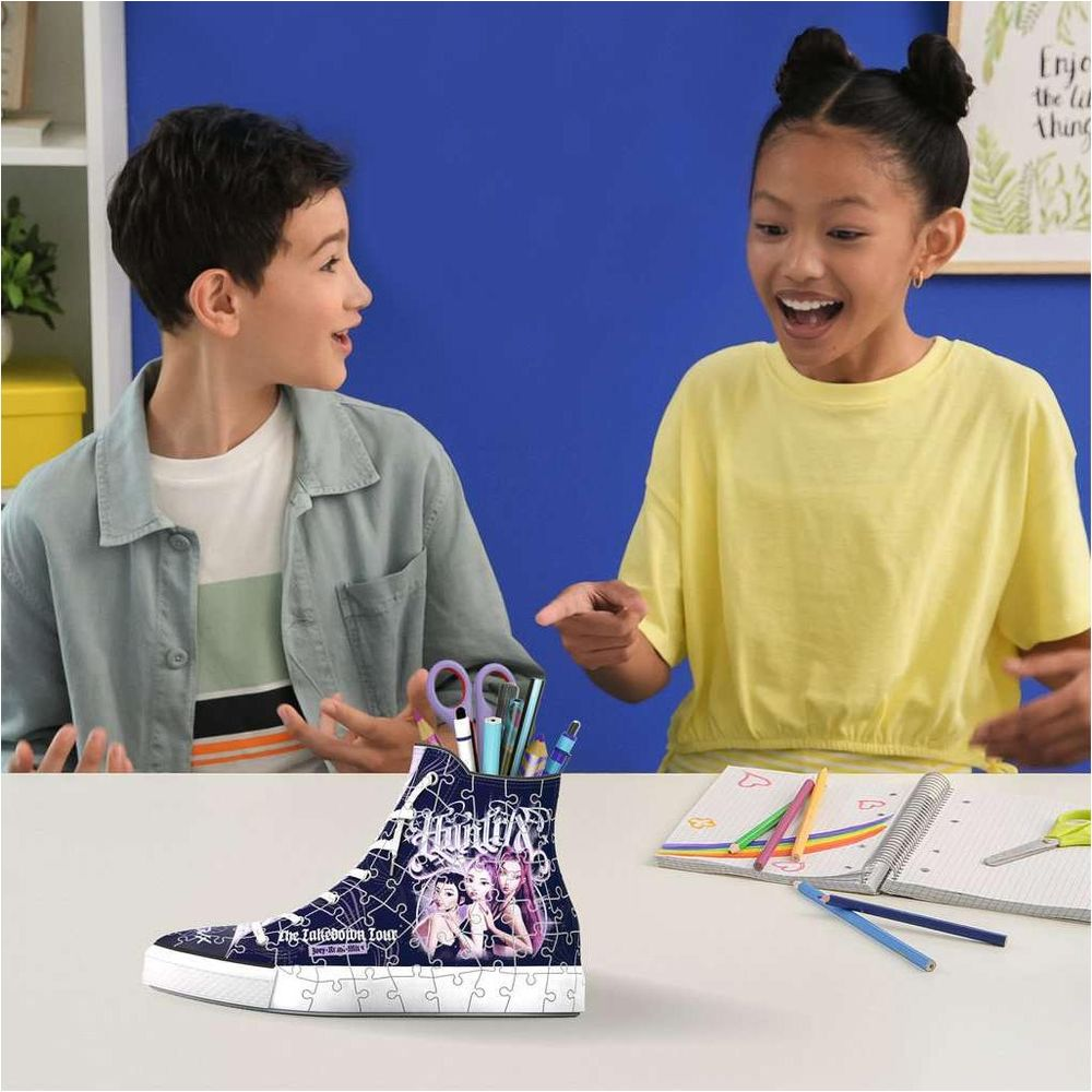Ein Junge und ein Mädchen betrachten begeistert einen sneakerförmigen Stiftehalter auf dem Tisch.