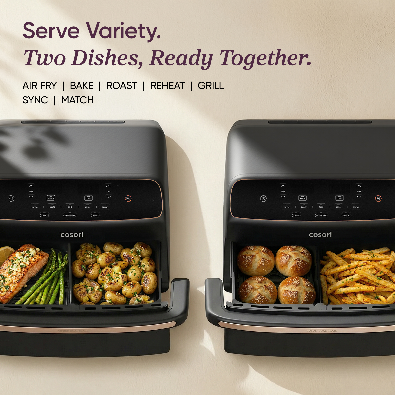 Two black Cosori air fryers with open baskets showing salmon, asparagus, potatoes, rolls, and fries, with promotional text.