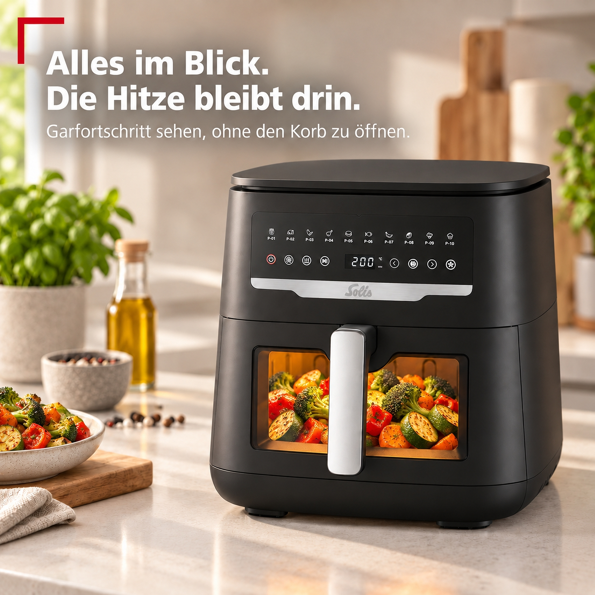 Schwarze Heißluftfritteuse mit beleuchtetem Sichtfenster voller Gemüse auf einer Küchenarbeitsplatte.