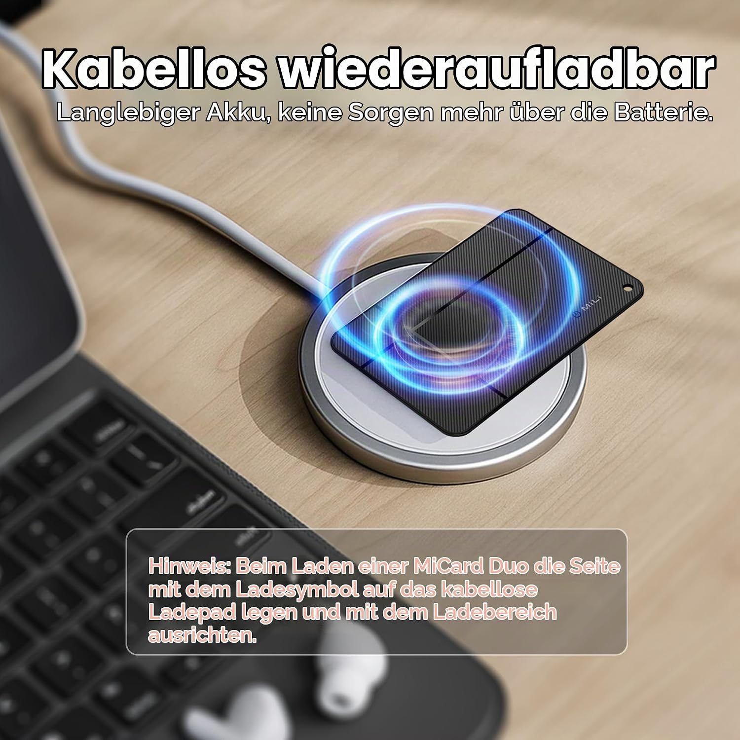Eine schwarze Karte lädt kabellos auf einem silbernen Pad neben einer Tastatur mit Textoverlays.