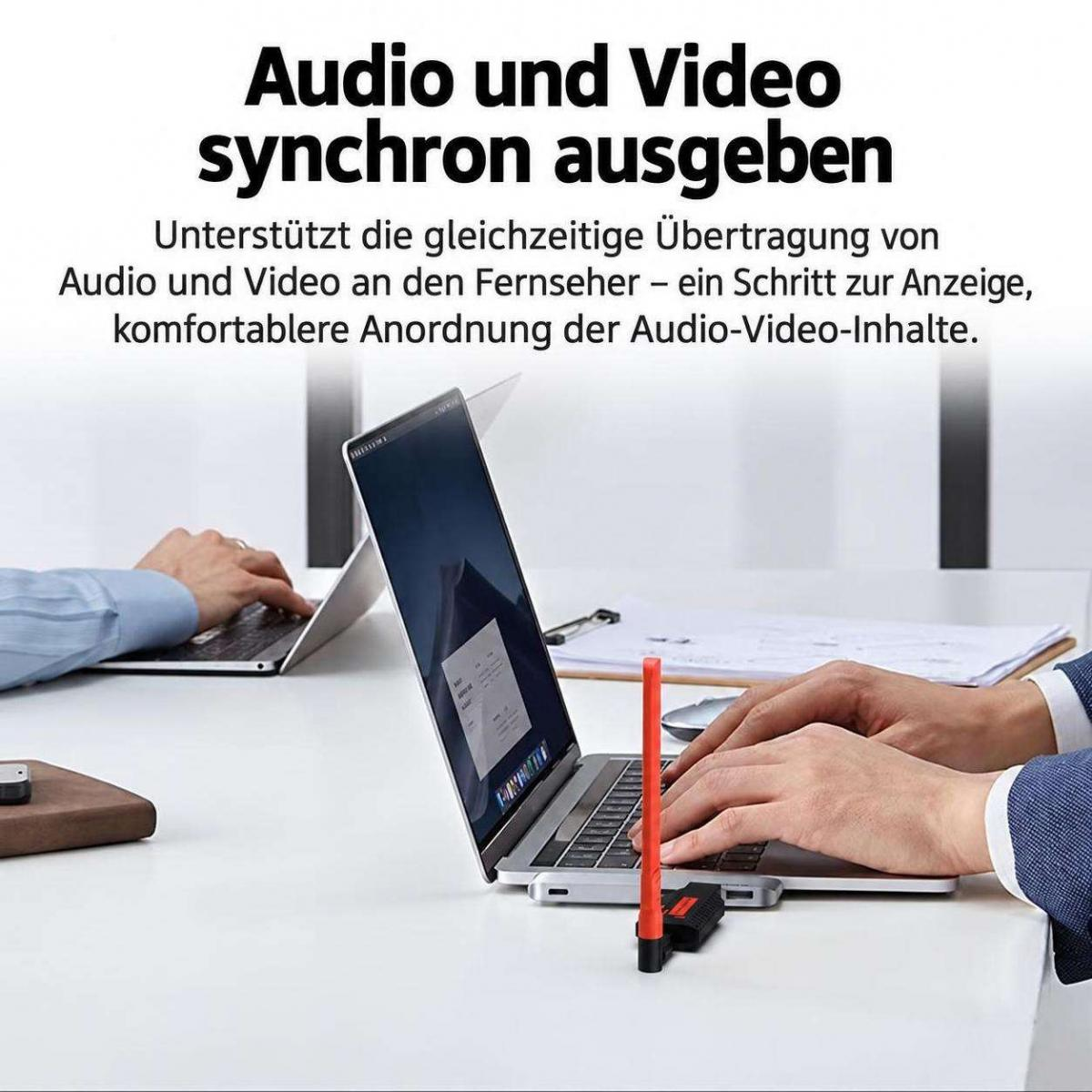Person tippt auf einem Laptop mit angeschlossenem roten Antennenadapter auf einem weißen Tisch.