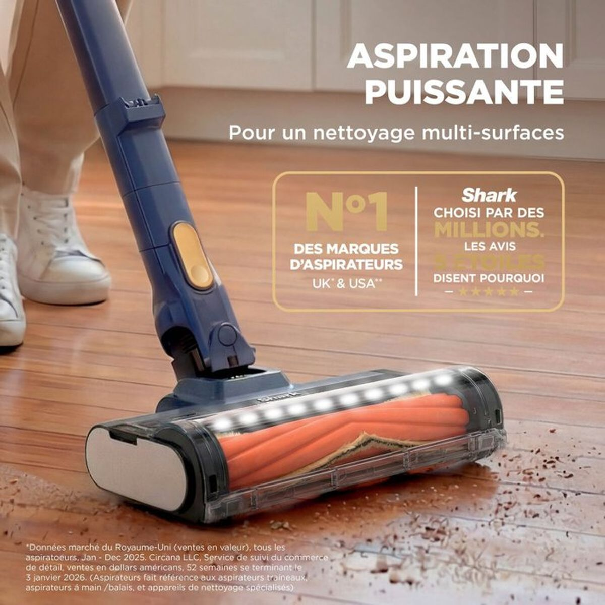 Un aspirapolvere Shark blu pulisce lo sporco su un pavimento di legno. Testo pubblicitario e premi.