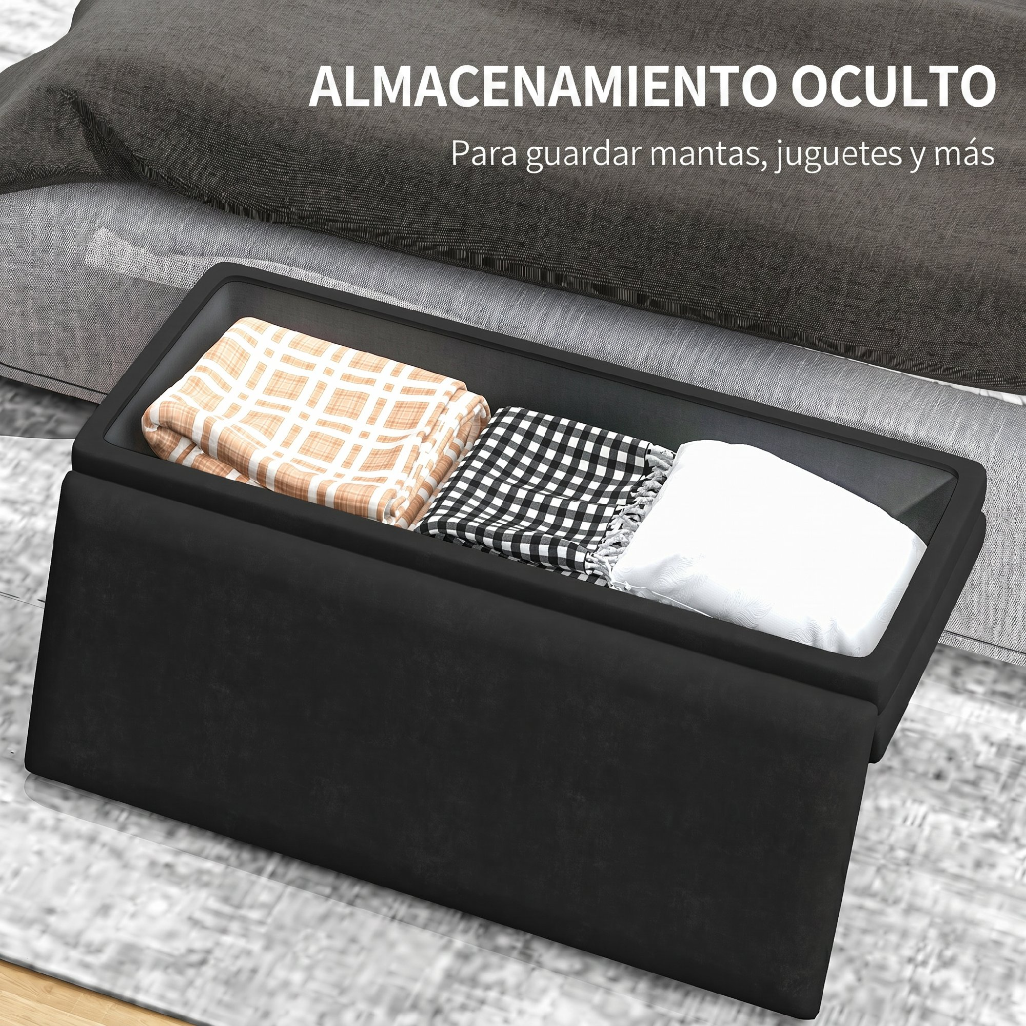 Caja de almacenamiento negra debajo de una cama, llena de mantas.