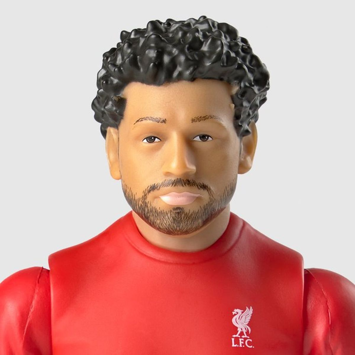 Nahaufnahme einer Fussballspieler-Figur mit lockigem schwarzen Haar, Bart und rotem Liverpool-Trikot.
