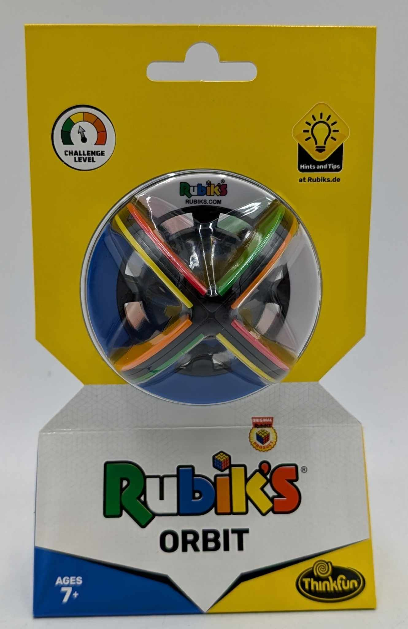 Verpackung des Rubik's Orbit Puzzles vor gelbem Hintergrund.
