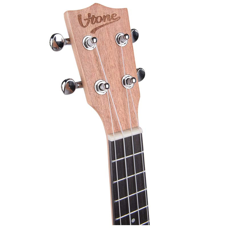 Nahaufnahme der Kopfplatte einer Ukulele aus Holz mit verchromten Mechaniken und Saiten.