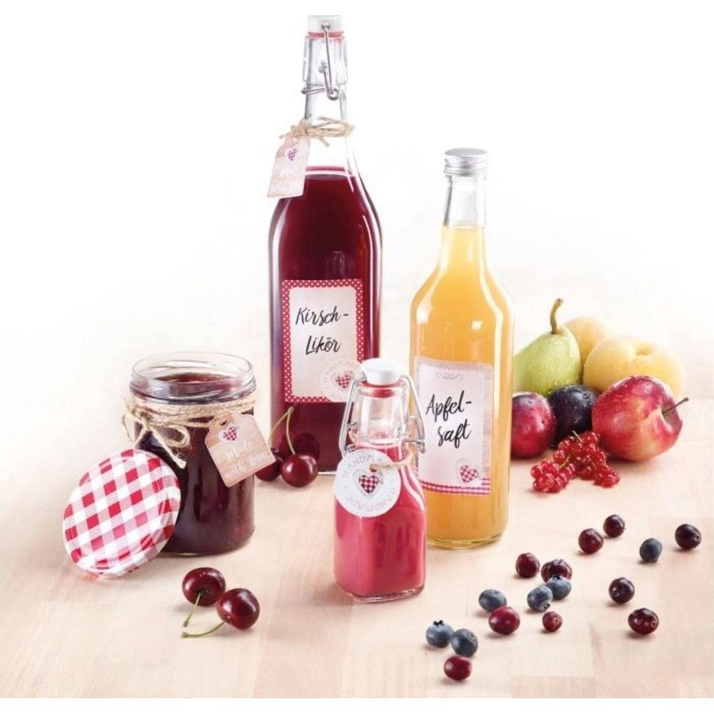 Bottiglie di succo e liquore, un barattolo di marmettata e frutta fresca disposti su una superficie di legno.