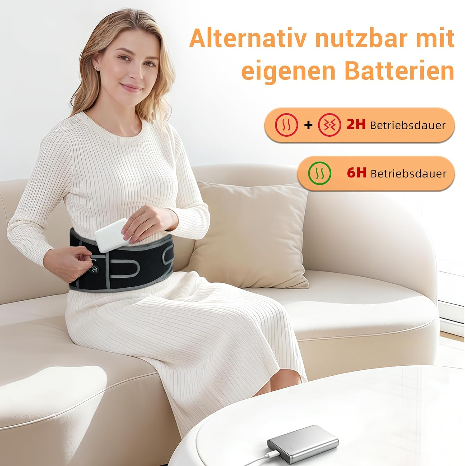 Eine Frau sitzt auf einem Sofa und steckt eine Powerbank in die Tasche eines Heizgürtels.