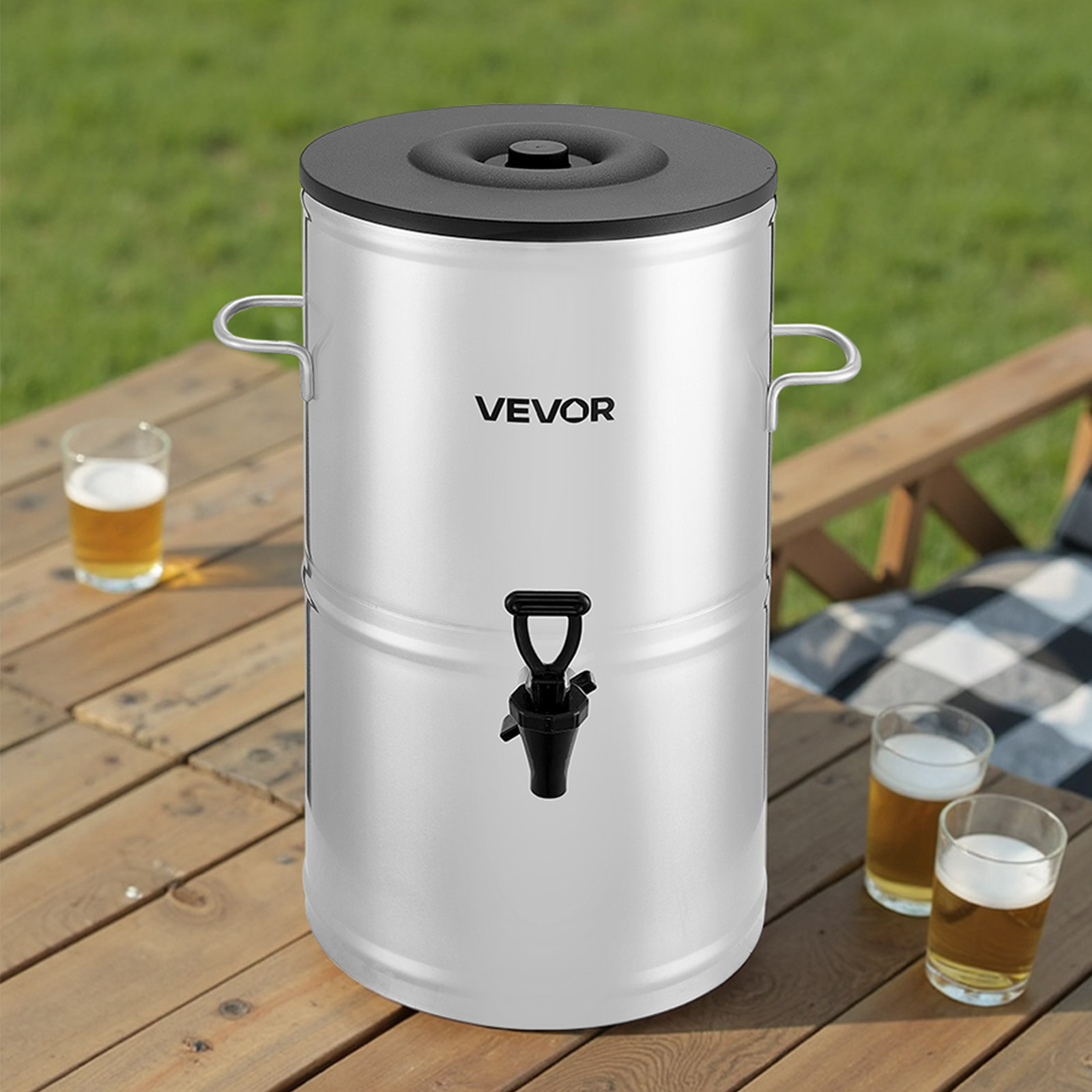 Un distributore di bevande argento VEVOR con coperchio e rubinetto neri è su un tavolo di legno con bicchieri di birra.