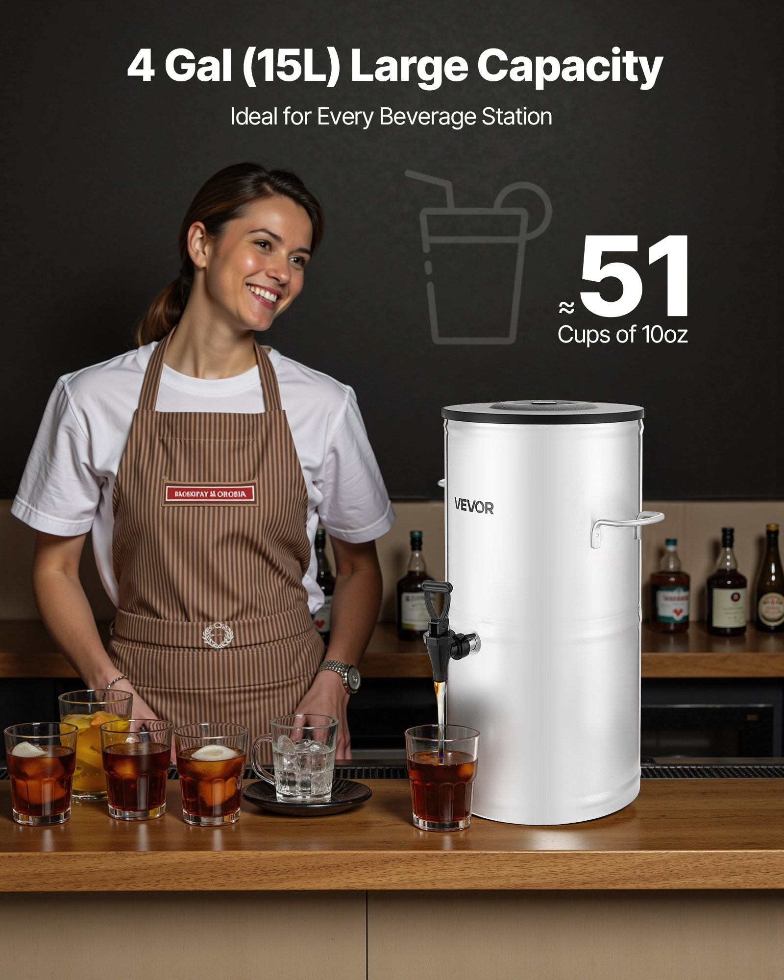 Una donna sorridente con grembiule accanto a un grande dispenser di bevande argentato versa succo in un bicchiere.