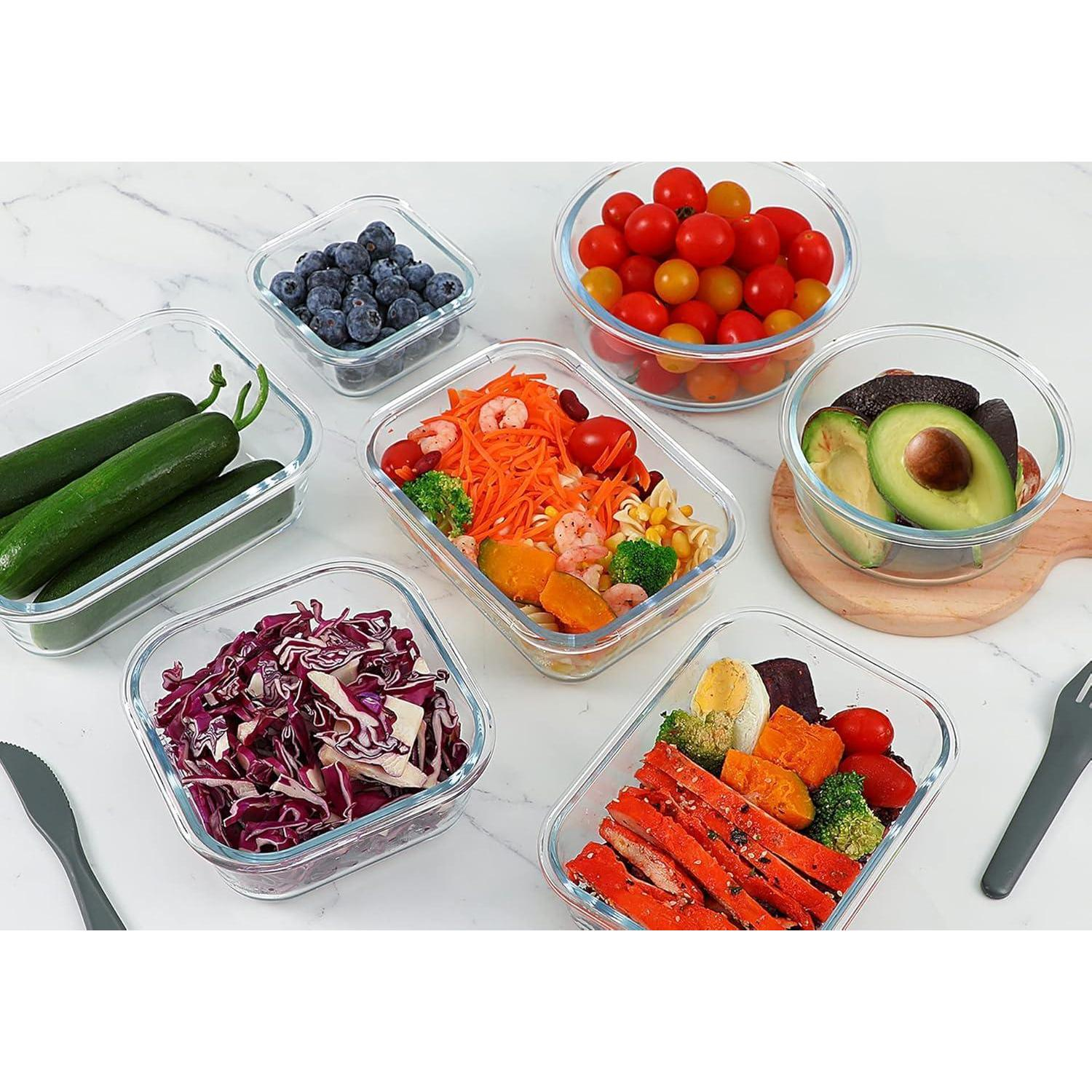 Contenitori di vetro su una superficie bianca con prodotti freschi come cetrioli, mirtilli, pomodori, insalata e avocado.