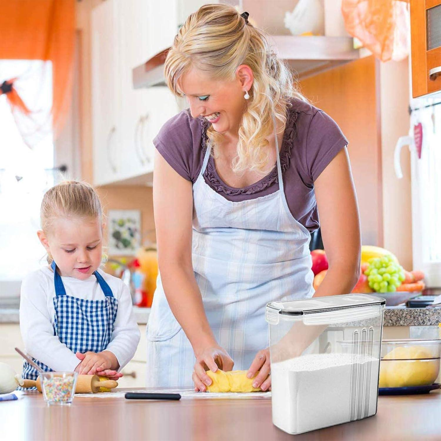Una donna e una bambina preparano l'impasto in una cucina luminosa, vicino a un contenitore di farina.