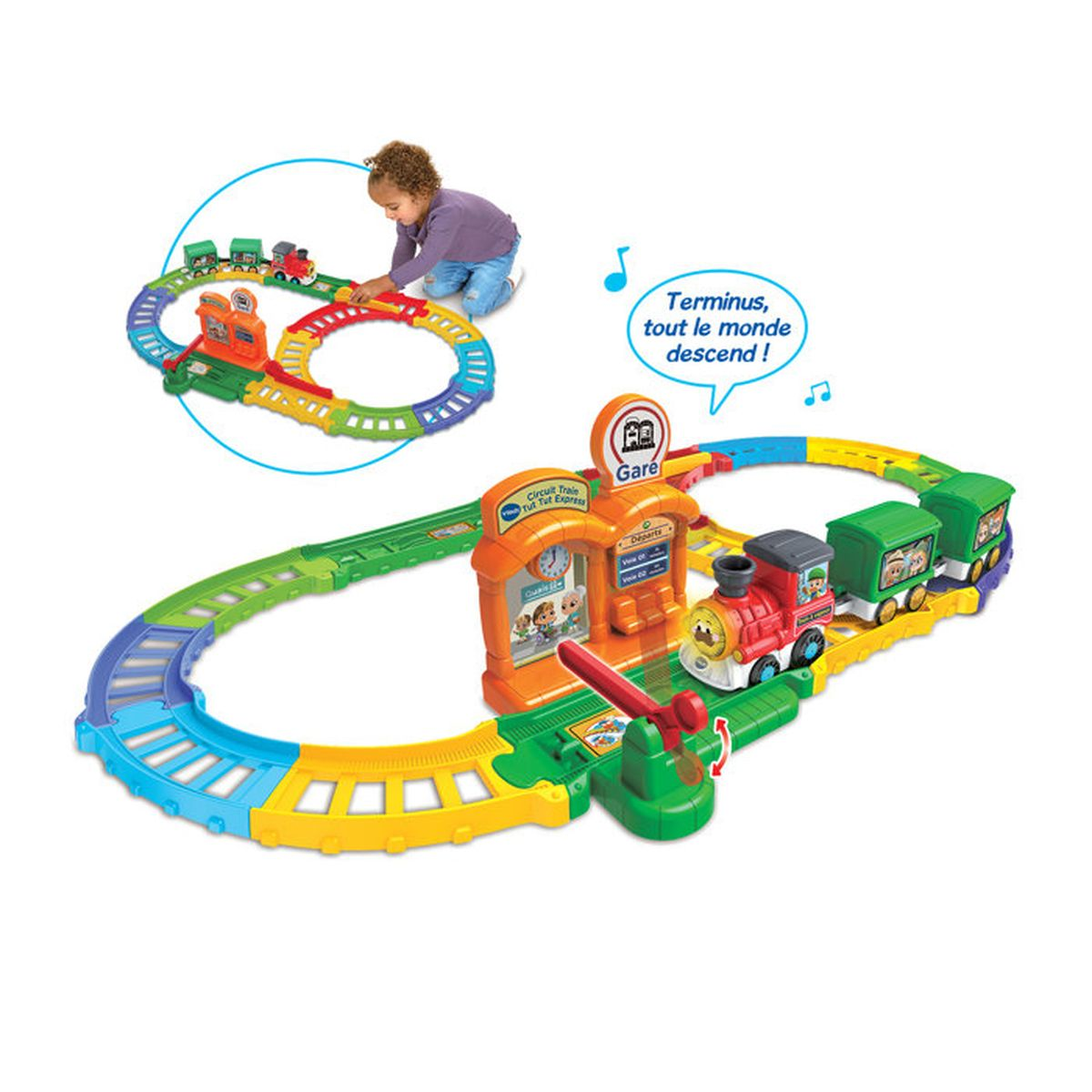 Buntes Spielzeug-Zugset mit einer Lokomotive, grünen Anhängern und einer Bahnhofsstation, ein Kind spielt im Hintergrund.