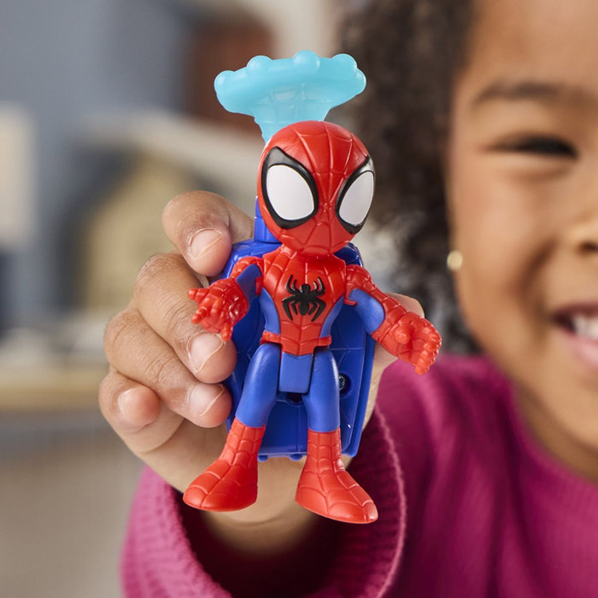 Un enfant tient une figurine de Spider-Man avec un accessoire bleu.
