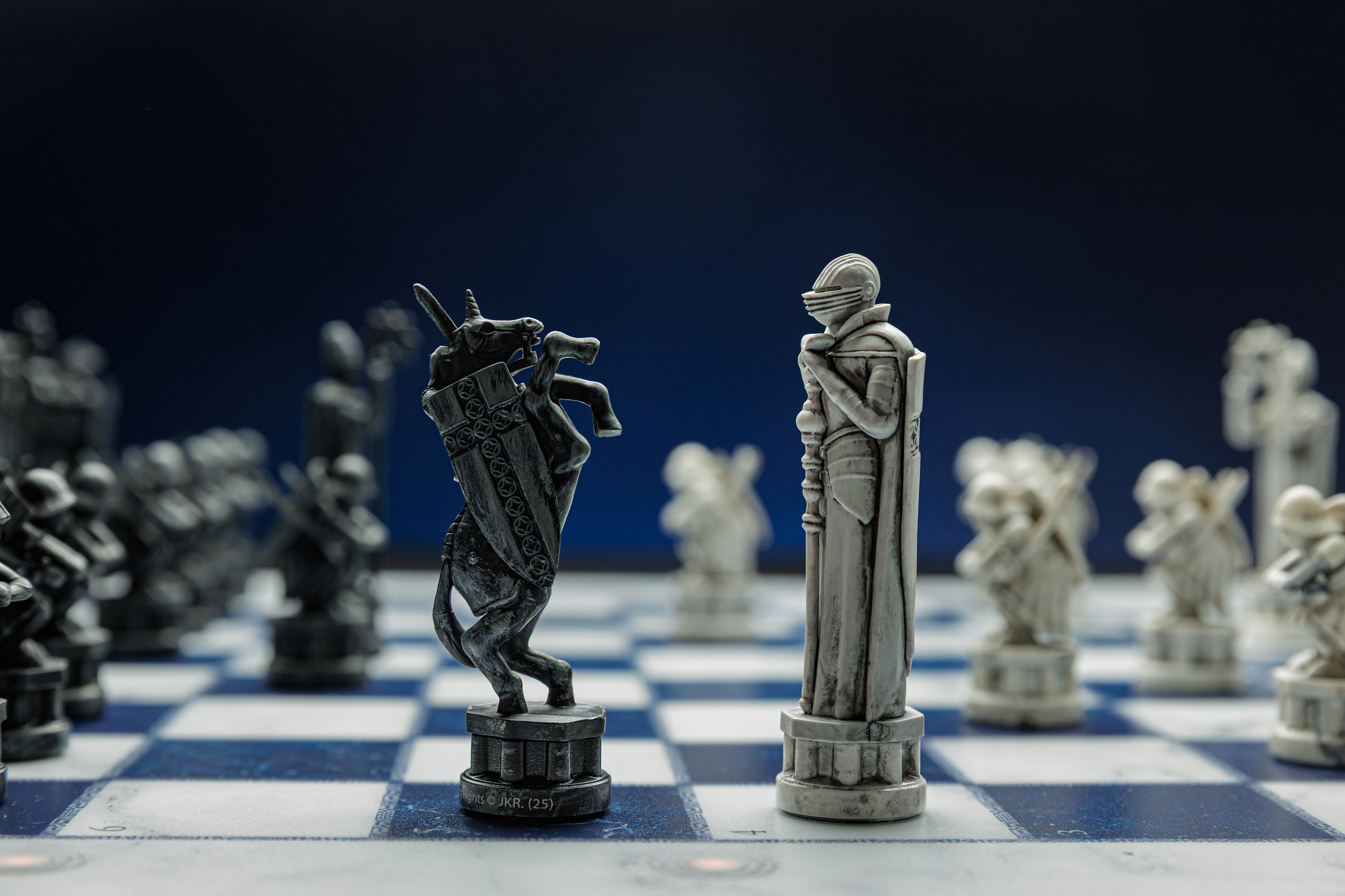 Pi èces d'échecs fantastiques détaillées sur un damier bleu et blanc, face à face.