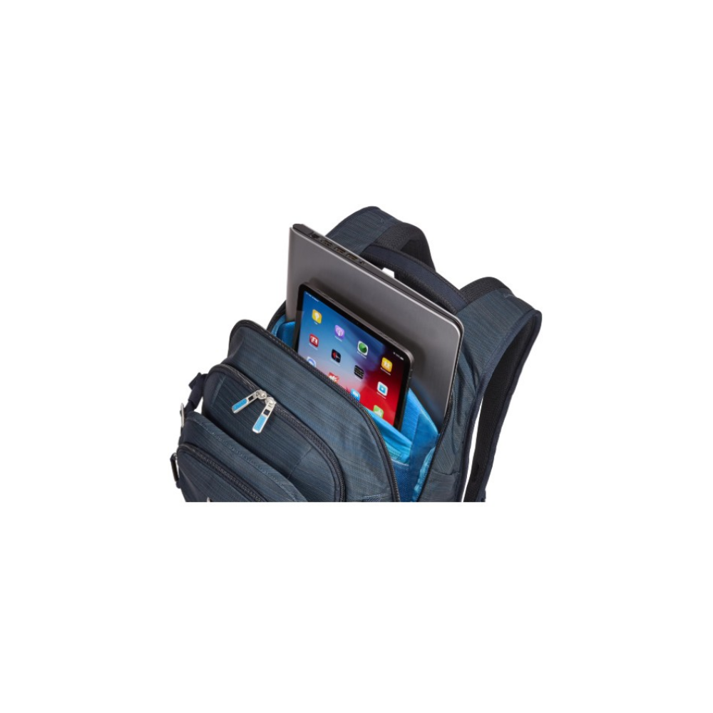 Ein blauer Rucksack mit einem Laptop und einem Tablet im offenen Hauptfach gegen wei1en Hintergrund.