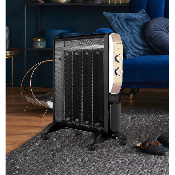 Una stufa elettrica nera si trova su un tappeto grigio davanti a un divano blu.