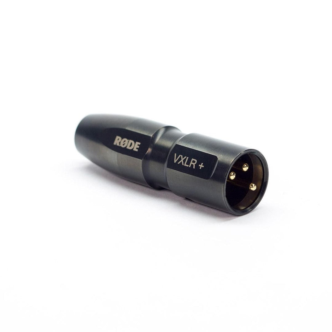 Un adattatore da XLR a 3,5 mm Rode VXLR+ nero si trova su una superficie bianca.