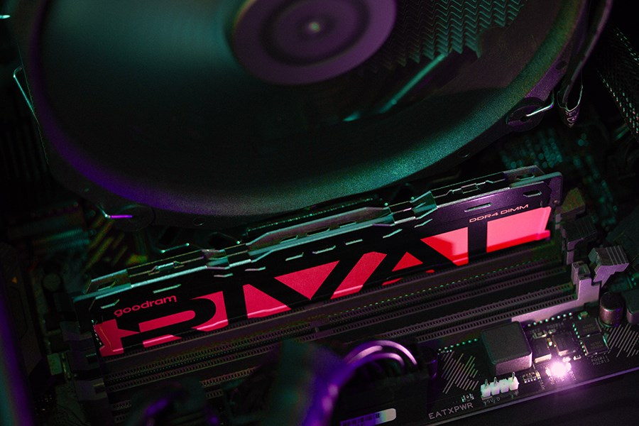 Zbliżenie płyty głównej z pamięcią RAM Goodram i chłodzeniem CPU w fioletowo-czerwonym świetle.