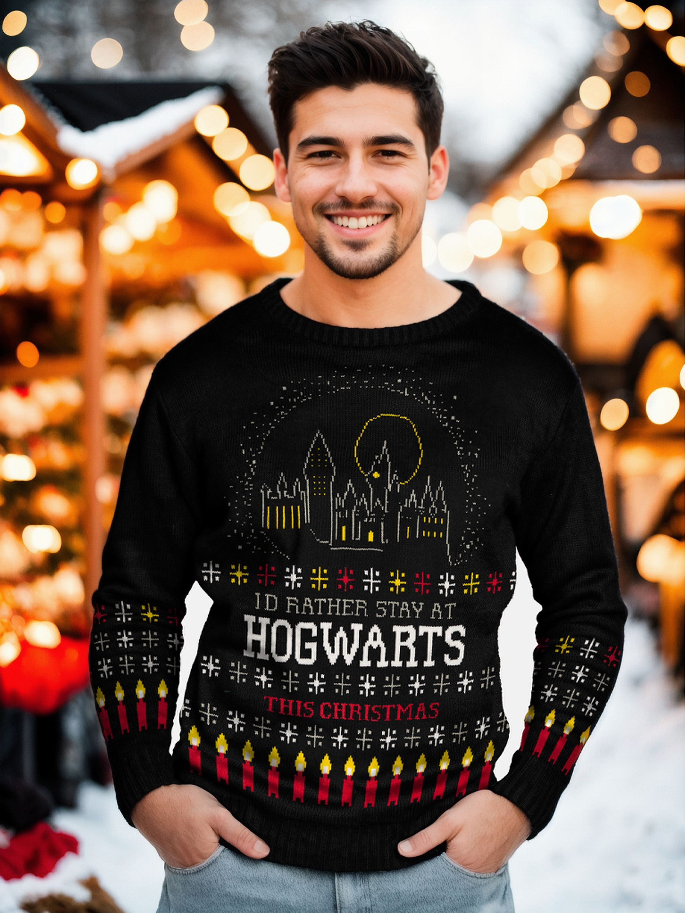 Ein lächelnder Mann trägt einen schwarzen Hogwarts-Weihnachtspullover auf einem Markt.