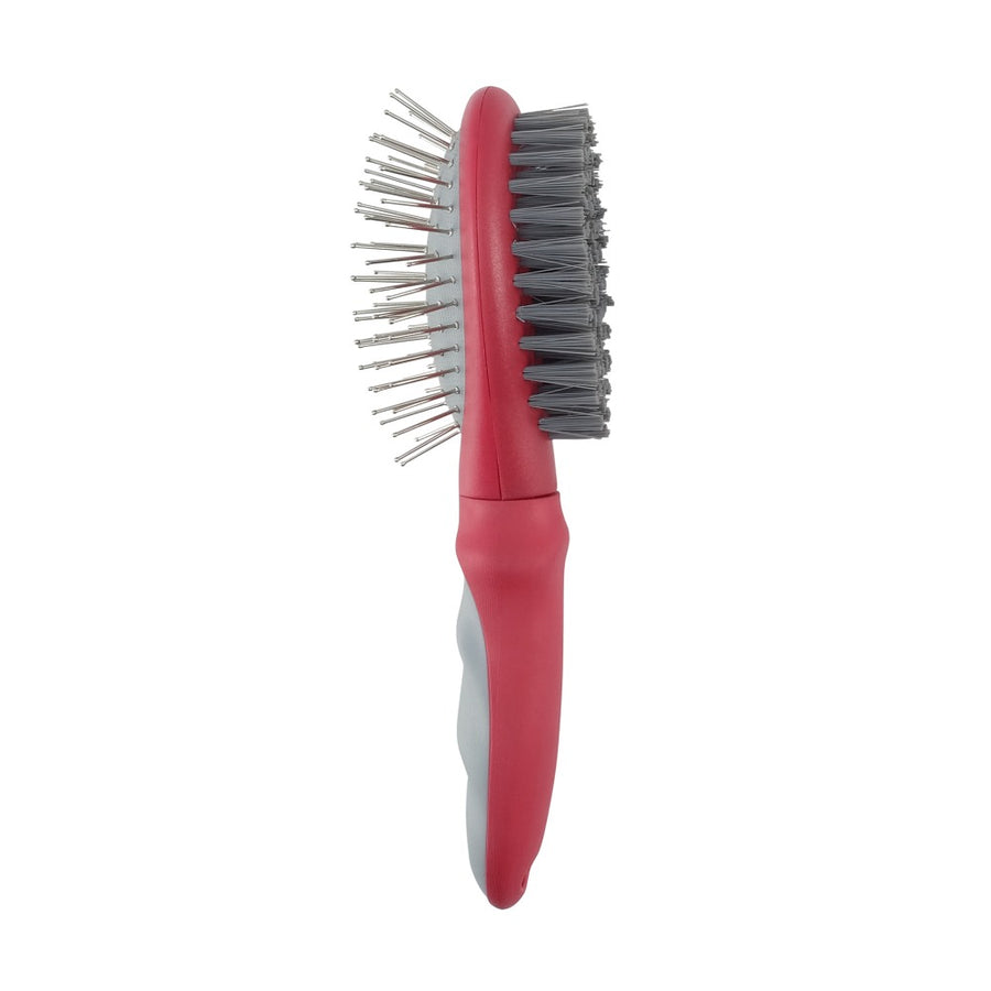 Un cepillo de doble cara para mascotas con mango rosa, púas metálicas en un lado y cerdas de nailon en el otro.