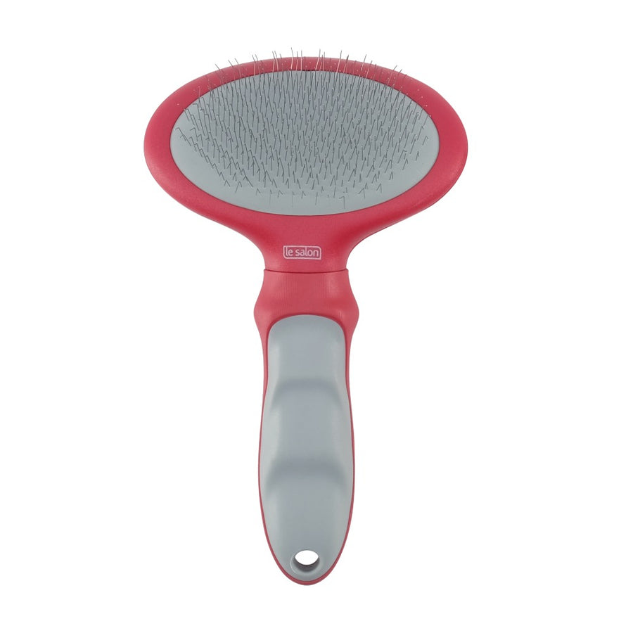 Un cepillo para mascotas rosa y gris con cerdas de alambre finas y curvadas.