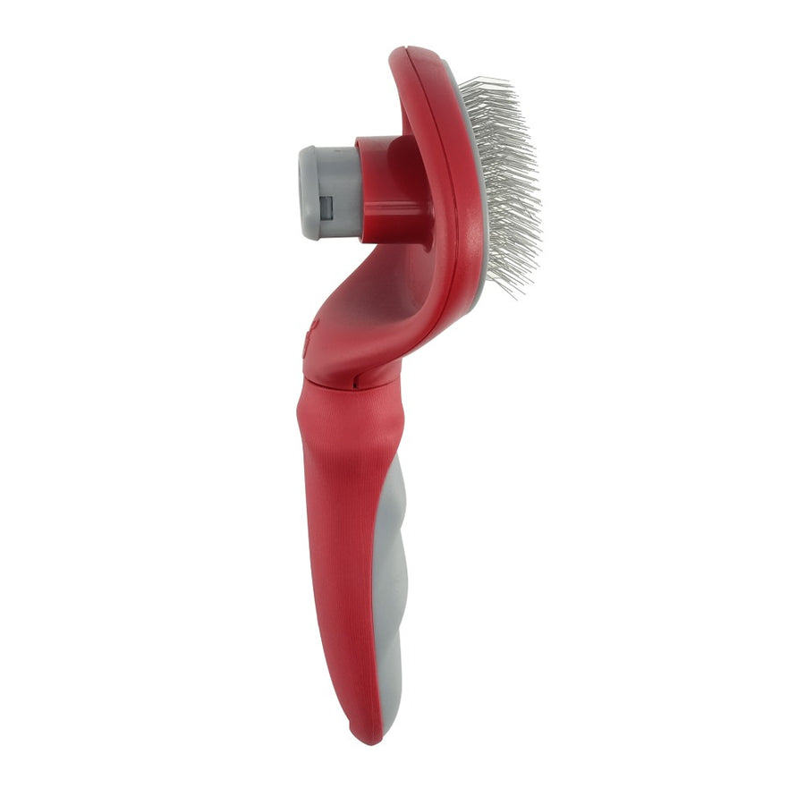 Un cepillo para mascotas rojo y gris con cerdas finas de alambre metálico, visto de lado sobre un fondo blanco.