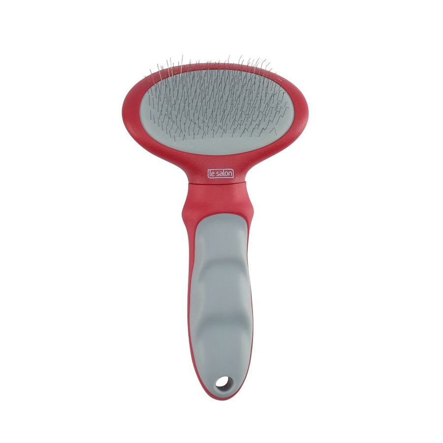 Un cepillo cardador rojo y gris para mascotas con finas púas de metal sobre fondo blanco.