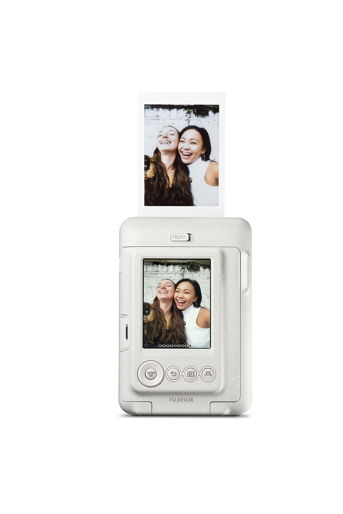 Beyaz bir Fujifilm anlık kamera, beyaz arka planda gülen iki genç kadının basılı fotoğrafını gösteriyor.