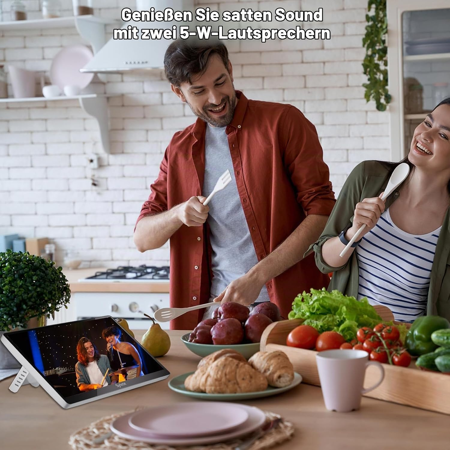 Una pareja en una cocina canta usando cucharas de madera como micrófonos junto a una tablet.