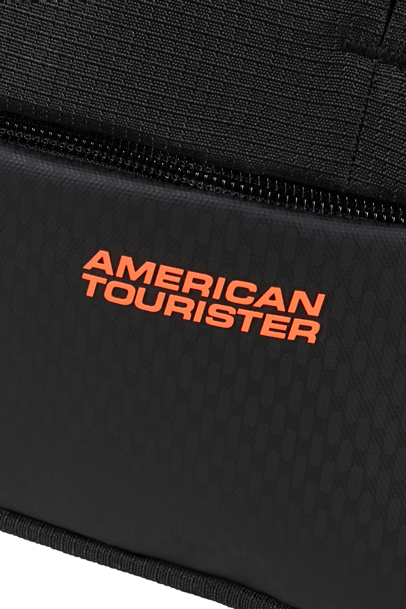 Zbliżenie czarnego plecaka American Tourister z pomarańczowym logo.