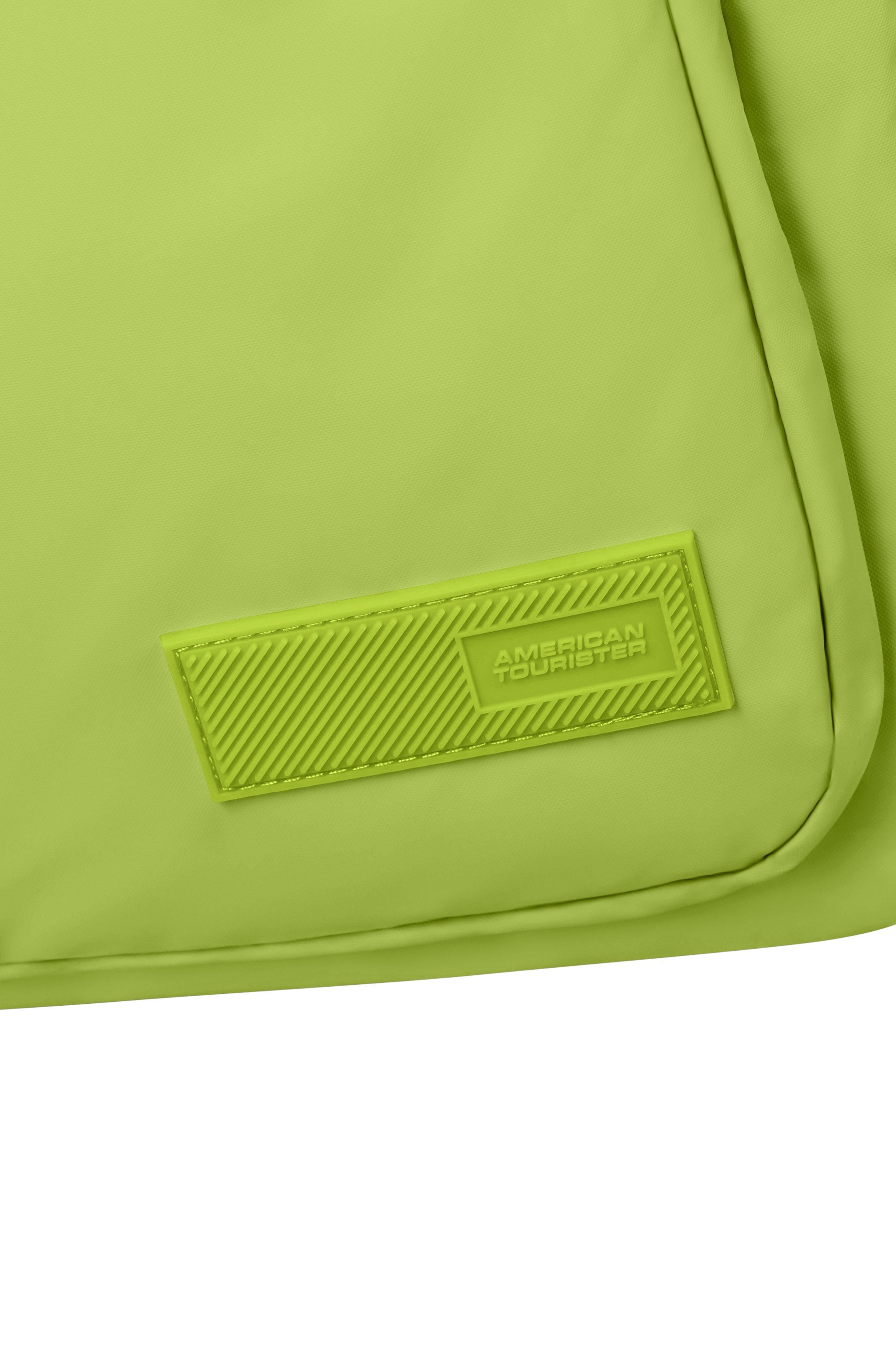 Jasnozielona torba z wytłoczonym logo American Tourister na gumowej naszywce.