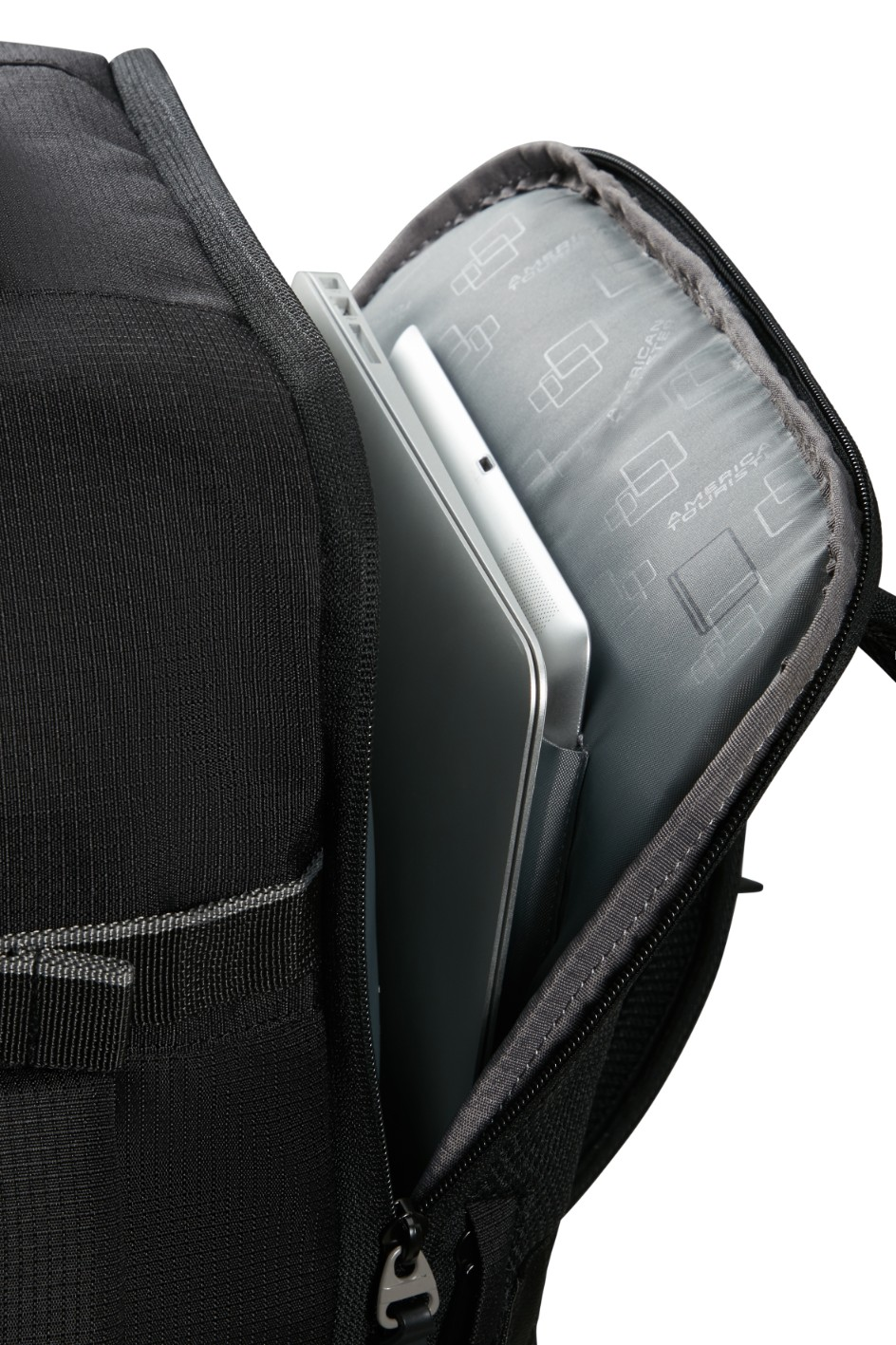 Otwarty czarny plecak ukazuje laptopa i tablet w wyściełanej komorze.