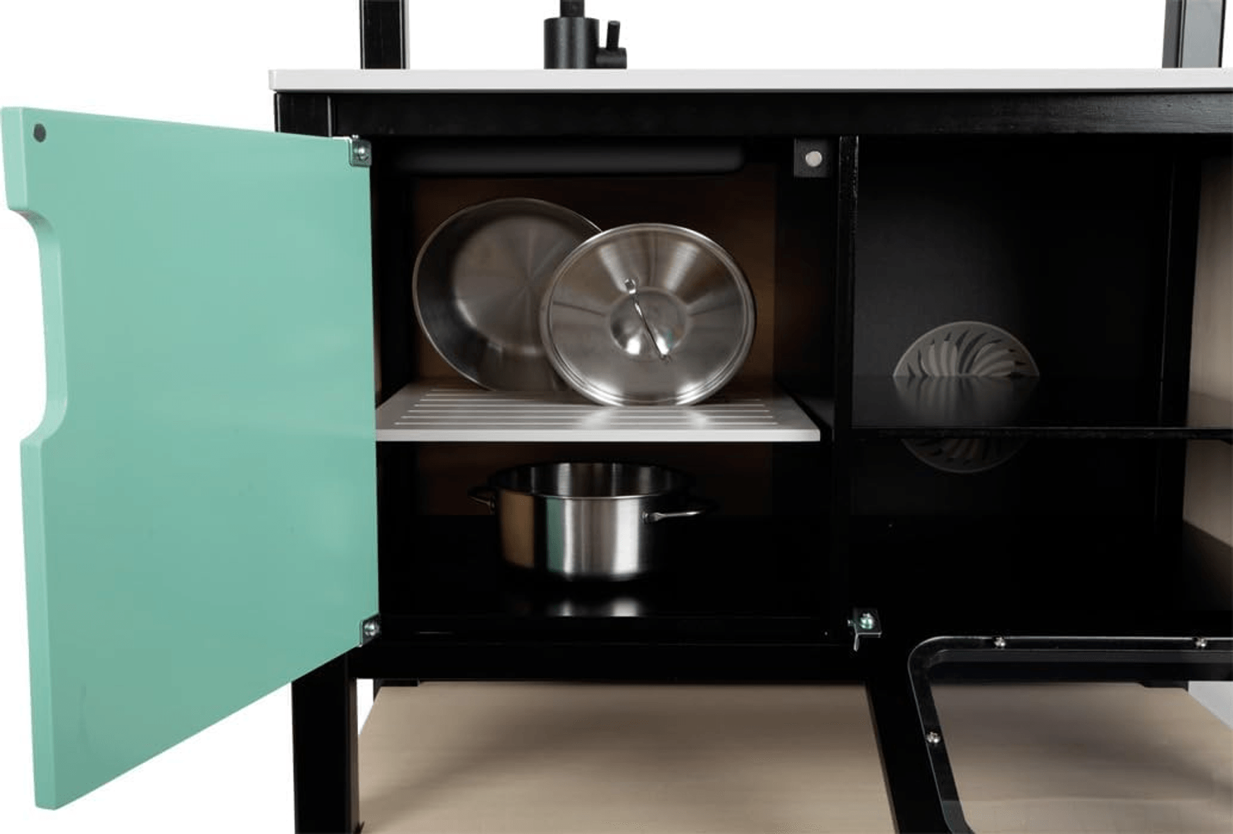 Cocina de juguete negra con puerta verde menta abierta, ollas y tapas dentro.
