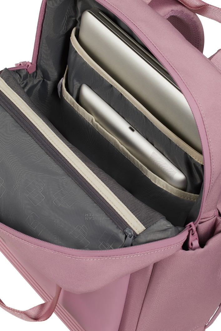 Otwarty różowy plecak z wyściełanymi przegrodami na laptopa i tablet w komorze głównej.
