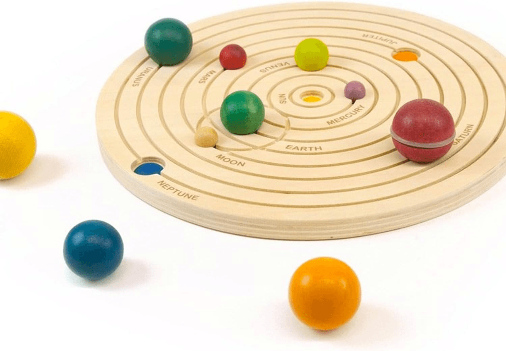 Juguete de madera con pistas circulares y bolas de colores como planetas sobre fondo blanco.